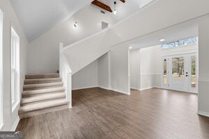 additional living space with vaulted ceiling, light carpet, and ceiling fan