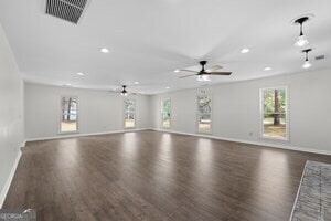 kitchen with dark hardwood / wood-style floors, a breakfast bar area, cream cabinetry, appliances with stainless steel finishes, and decorative light fixtures