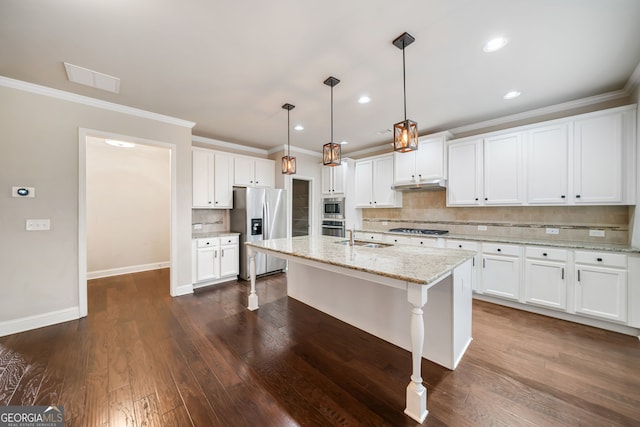 kitchen with under cabinet range hood, white cabinets, appliances with stainless steel finishes, and a sink