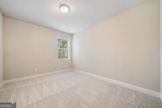 unfurnished room featuring baseboards, visible vents, and light carpet