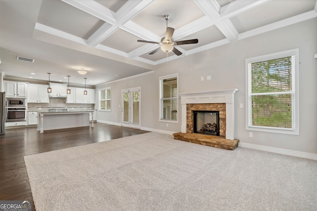 unfurnished living room with baseboards, coffered ceiling, and ceiling fan