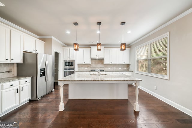 kitchen featuring a kitchen bar, a sink, appliances with stainless steel finishes, crown molding, and baseboards