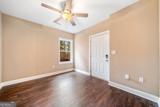 unfurnished room featuring dark wood finished floors, visible vents, baseboards, and ceiling fan