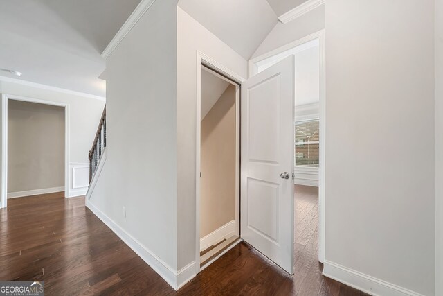 hallway featuring dark wood-style floors, baseboards, and ornamental molding