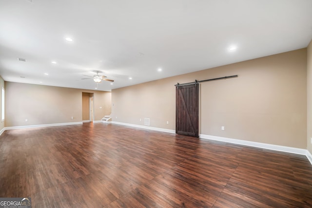 empty room featuring recessed lighting, a barn door, baseboards, and ceiling fan