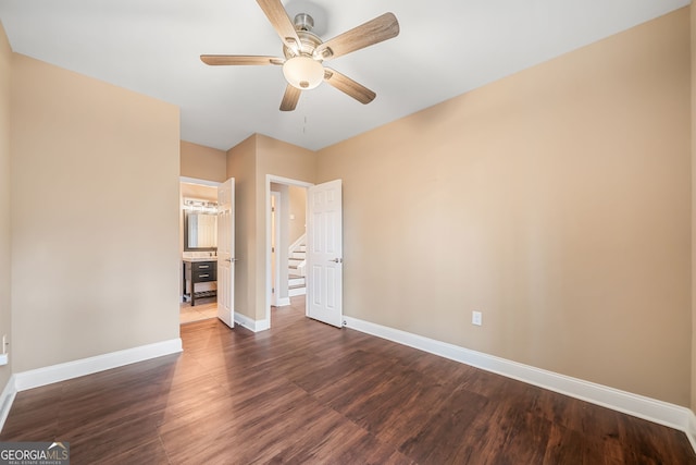 unfurnished bedroom with a ceiling fan, dark wood-style floors, and baseboards