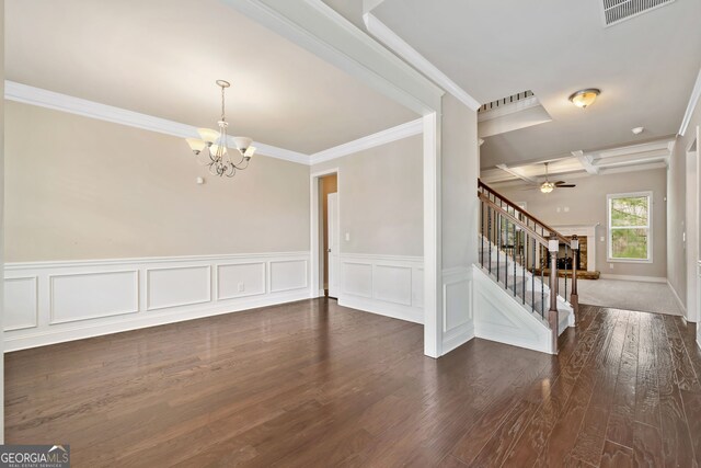 spare room with visible vents, dark wood-type flooring, crown molding, stairway, and ceiling fan with notable chandelier
