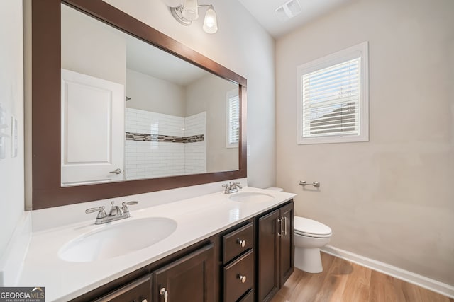 bathroom featuring a sink, visible vents, toilet, and double vanity