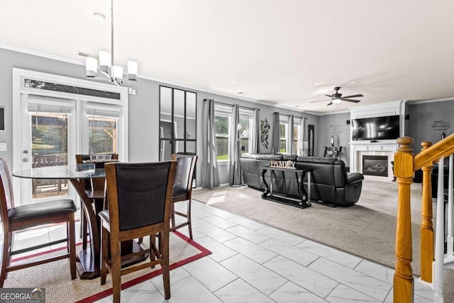 dining room with ceiling fan with notable chandelier, ornamental molding, and light carpet