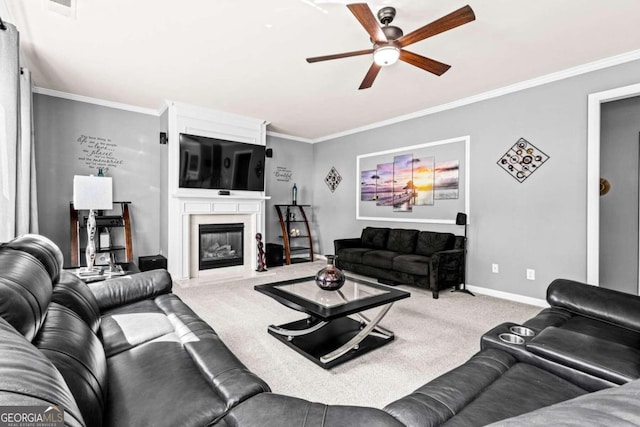 living room featuring ceiling fan, a fireplace, crown molding, and carpet flooring