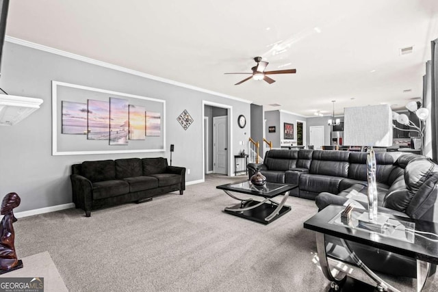 carpeted living room featuring ceiling fan with notable chandelier and crown molding