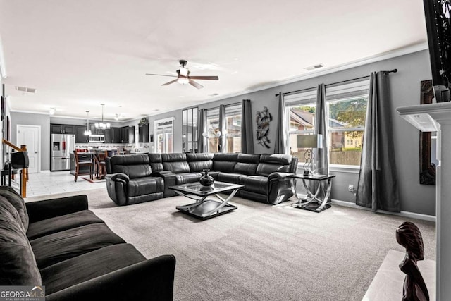 living room with ornamental molding, ceiling fan, and light colored carpet