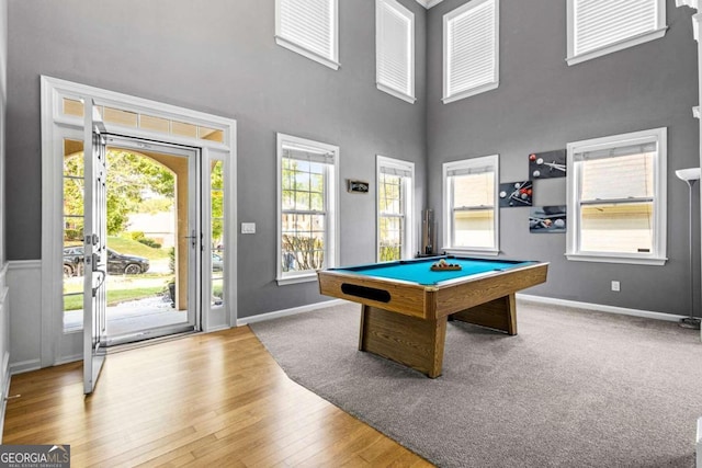 rec room featuring hardwood / wood-style flooring, a towering ceiling, billiards, and a wealth of natural light