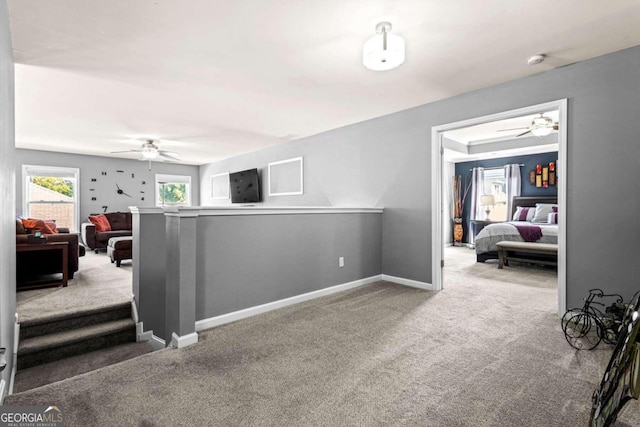 carpeted living room with ceiling fan with notable chandelier