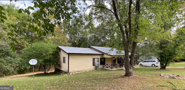 view of side of property featuring a lawn and a porch