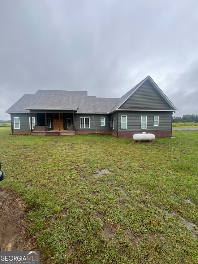 back of house with a lawn