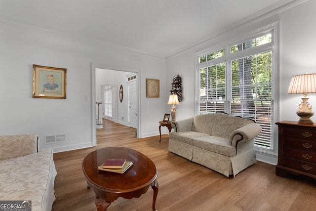 living room featuring light hardwood / wood-style flooring and crown molding