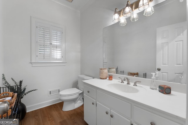 bathroom with toilet, a chandelier, hardwood / wood-style floors, ornamental molding, and vanity