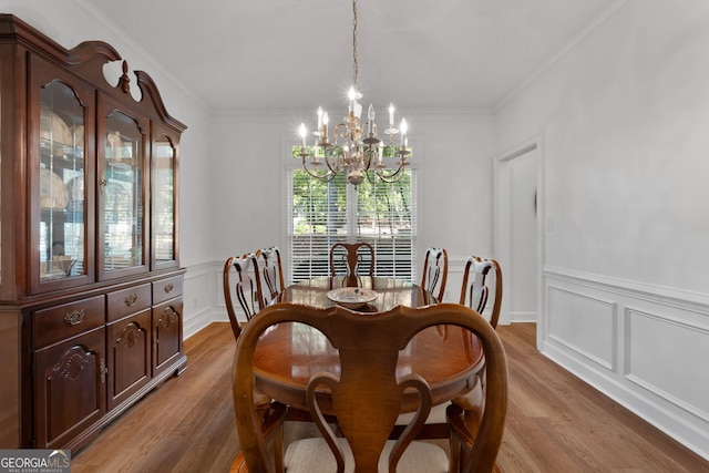 dining room with hardwood / wood-style flooring, crown molding, and a notable chandelier