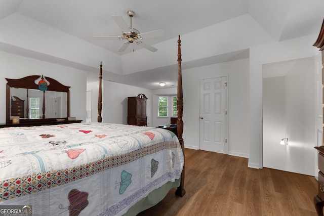 bedroom with ceiling fan, vaulted ceiling, and wood-type flooring