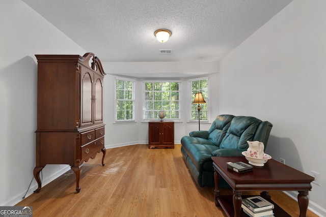 living area featuring light hardwood / wood-style flooring and a textured ceiling