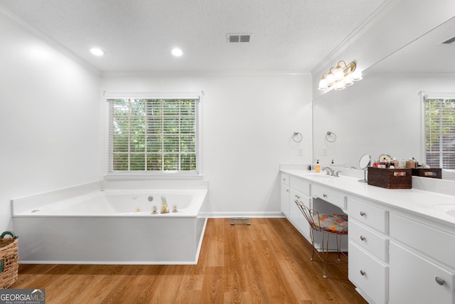 bathroom with hardwood / wood-style floors, vanity, a bathtub, a textured ceiling, and crown molding