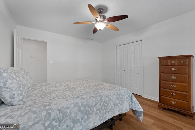 bedroom with light wood-type flooring, a closet, and ceiling fan