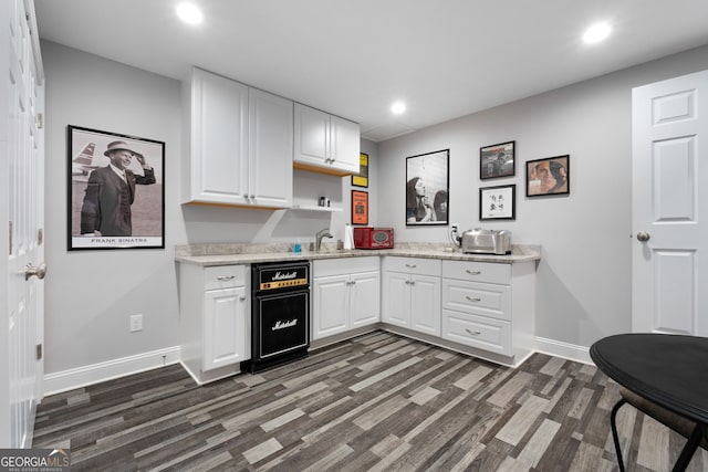 kitchen with sink, dark wood-type flooring, and white cabinets