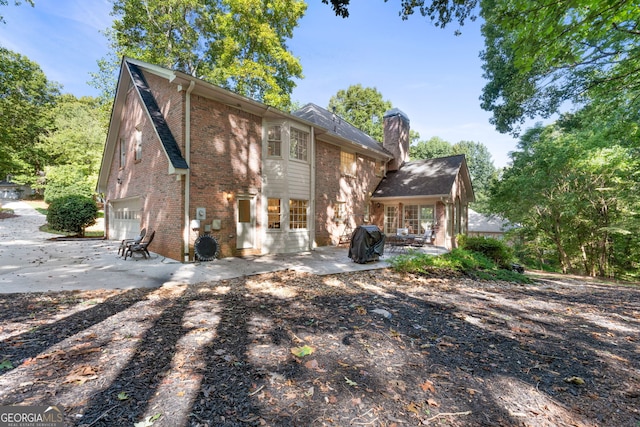 back of property with a patio and a garage