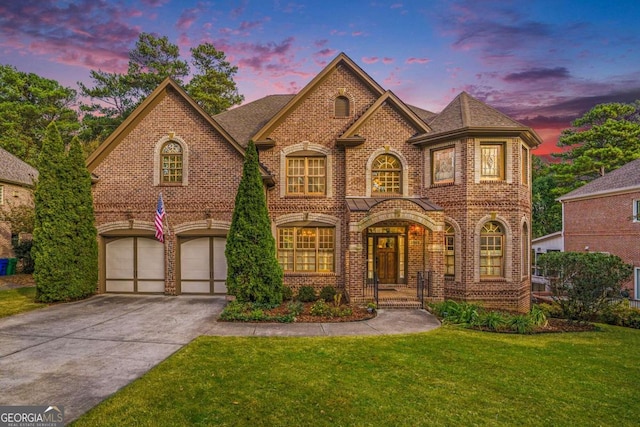 view of front of home with a garage and a lawn