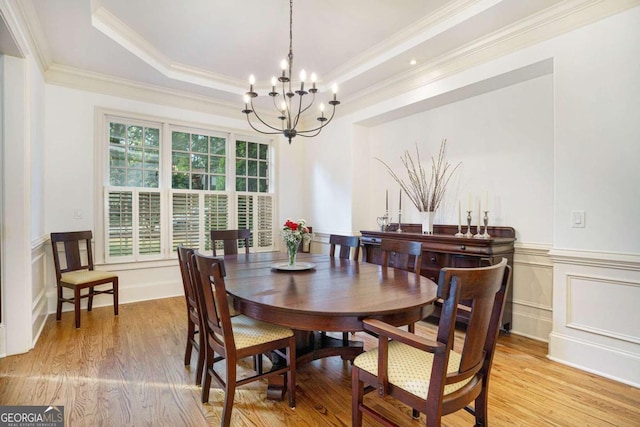 living room with ornamental molding, a high ceiling, and light hardwood / wood-style floors