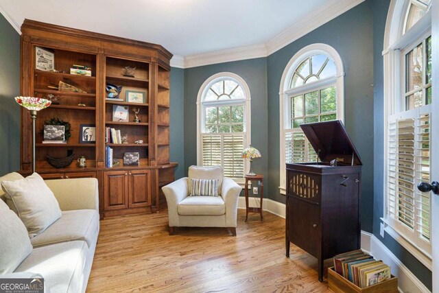 sitting room with crown molding, light hardwood / wood-style flooring, and french doors