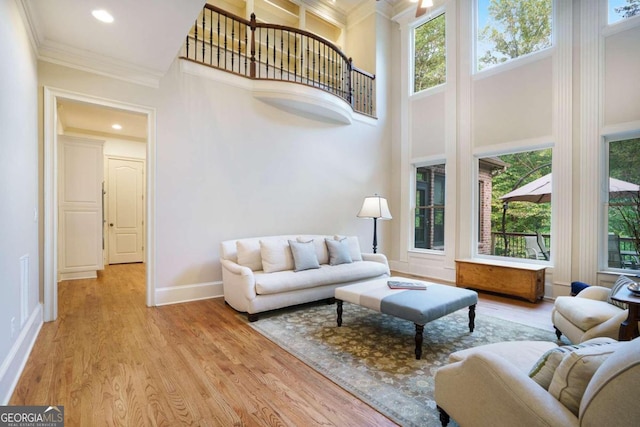 stairs featuring a high ceiling, a tray ceiling, wood-type flooring, ornamental molding, and an inviting chandelier