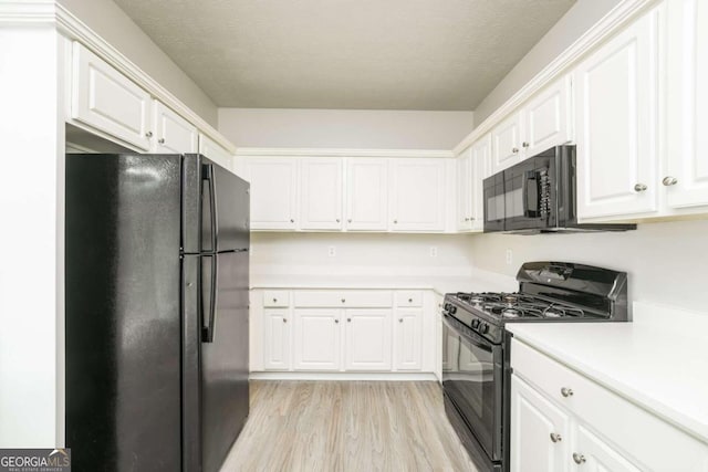 kitchen featuring white cabinets, black appliances, and light hardwood / wood-style floors