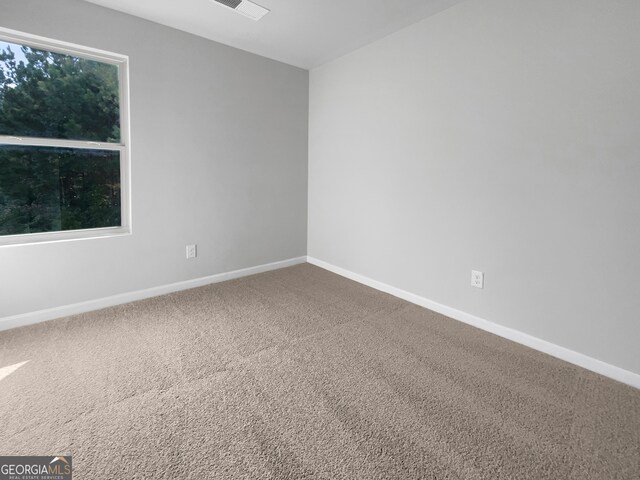 carpeted spare room featuring plenty of natural light