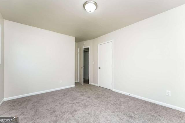 unfurnished room featuring light carpet