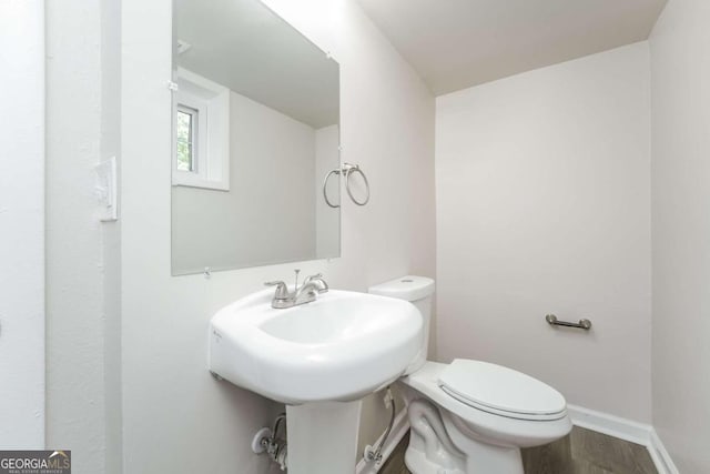 bathroom with hardwood / wood-style flooring and toilet