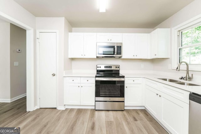 kitchen with white cabinets, appliances with stainless steel finishes, and sink