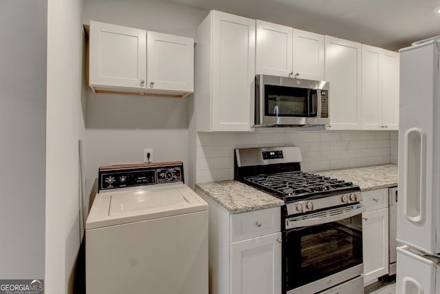 kitchen with white cabinetry, appliances with stainless steel finishes, washer / clothes dryer, and backsplash