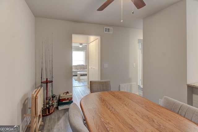 dining space with hardwood / wood-style floors and ceiling fan