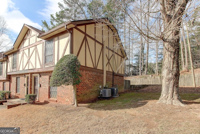 view of side of home featuring a yard and central AC unit