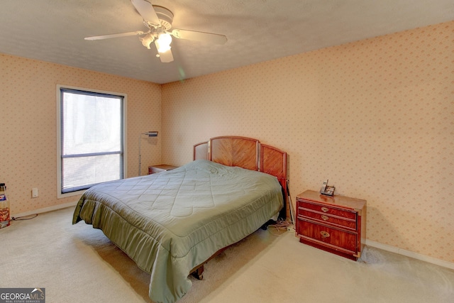 carpeted bedroom featuring a textured ceiling and ceiling fan