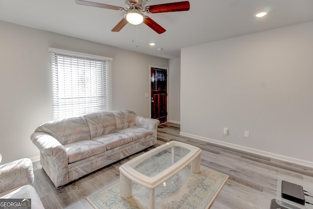 living room featuring ceiling fan and light hardwood / wood-style flooring