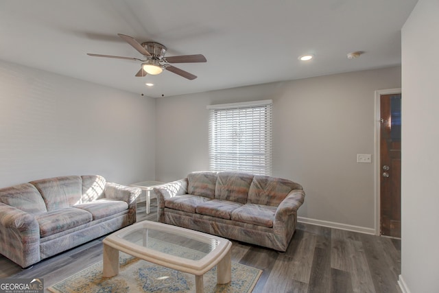 living room with dark hardwood / wood-style flooring and ceiling fan