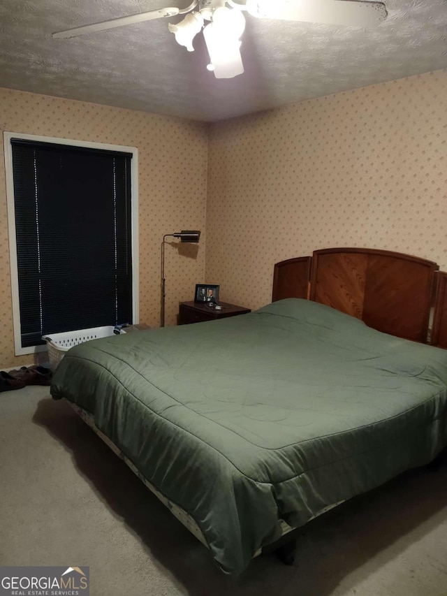 carpeted bedroom with a textured ceiling and ceiling fan