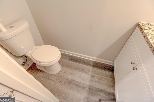 bathroom featuring vanity, hardwood / wood-style floors, and toilet