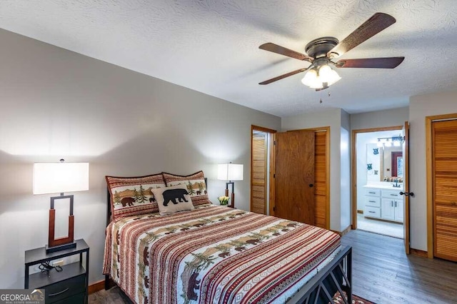 bedroom with baseboards, connected bathroom, ceiling fan, wood finished floors, and a textured ceiling