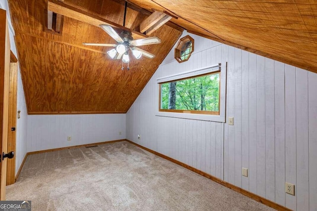 additional living space featuring lofted ceiling, ceiling fan, wooden ceiling, carpet floors, and wood walls