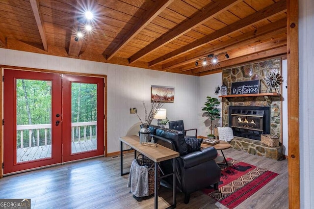 living room with beamed ceiling, a fireplace, wood finished floors, and wood ceiling