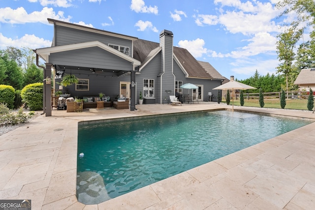 view of pool featuring an outdoor living space, ceiling fan, and a patio area